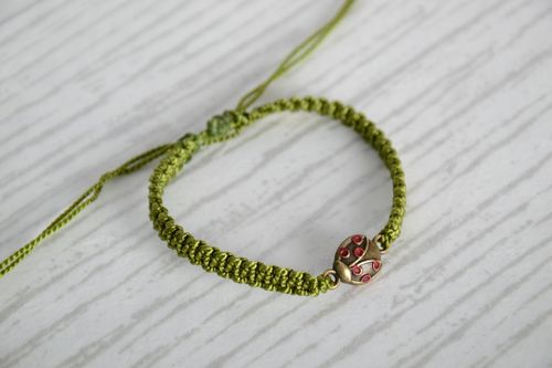 Handmade woven capron thread bracelet of green color with ladybug charm - MADEheart.com